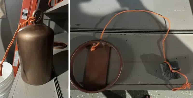 A copper bell with an attached wire and a black connector.