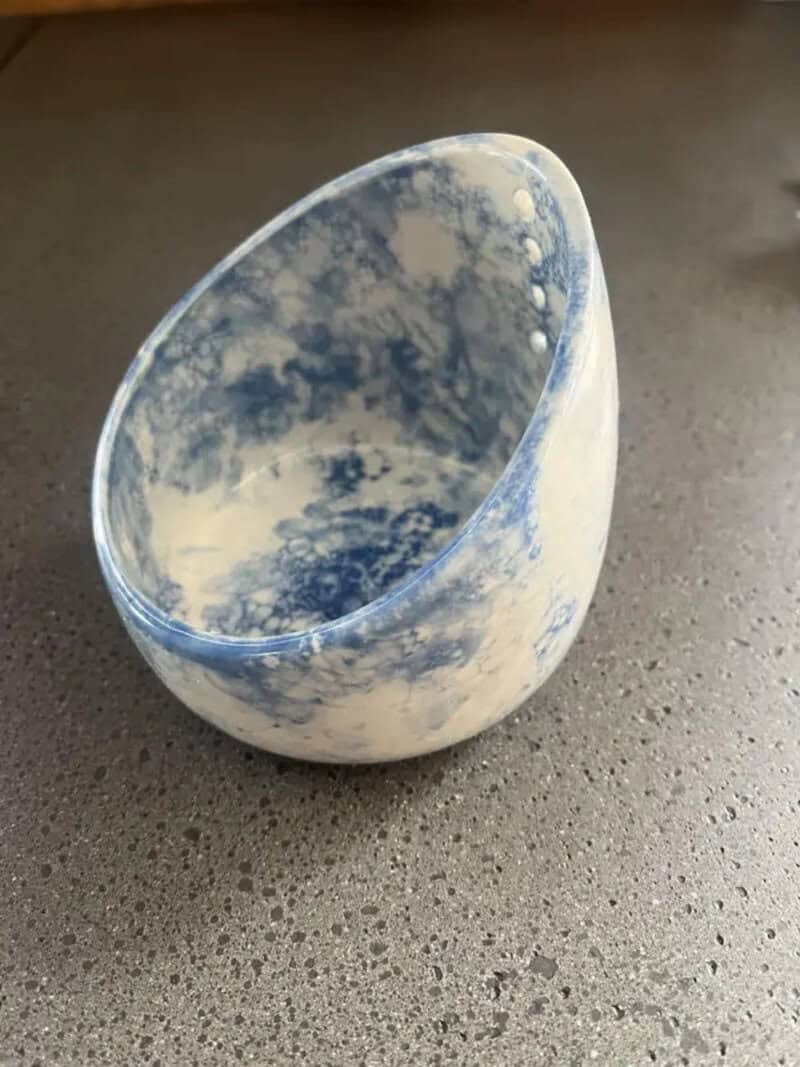 Ceramic bowl with blue and white cloud pattern on a gray surface.