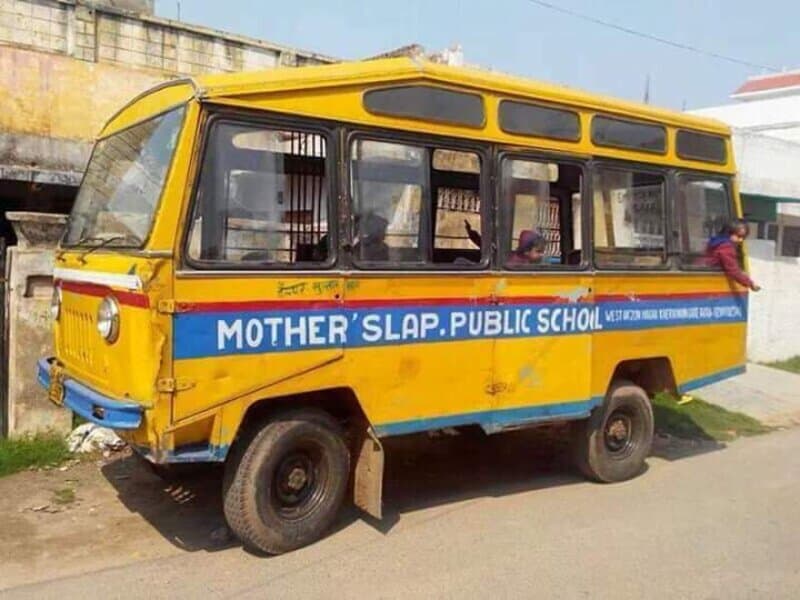 Yellow school bus with blue sign reading 'Mother's Slap Public School' parked on street.