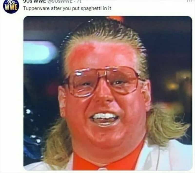 A person with long blonde hair, glasses, and a red face, smiling.