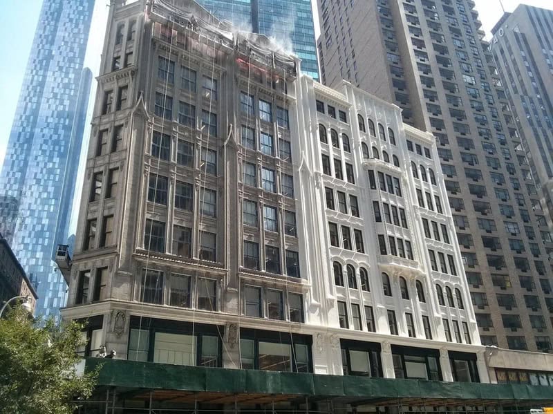 Building with smoke and water damage after fire, under construction, in a city.