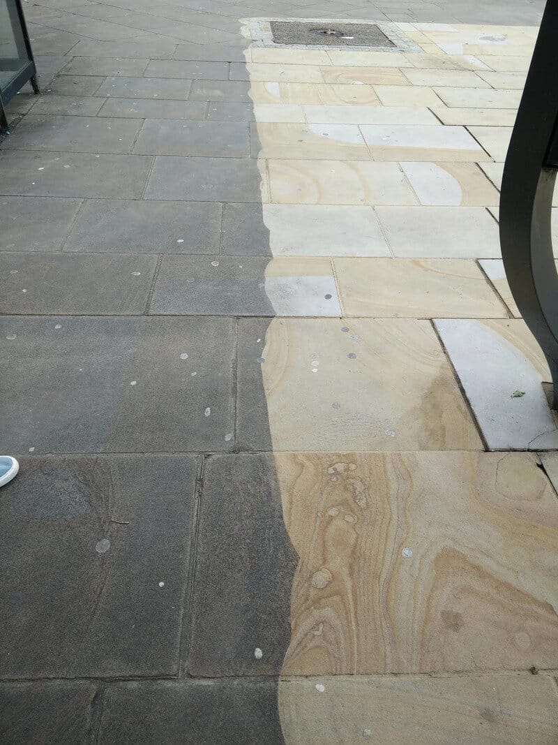 Side-by-side comparison of dirty and cleaned pavement after power washing.