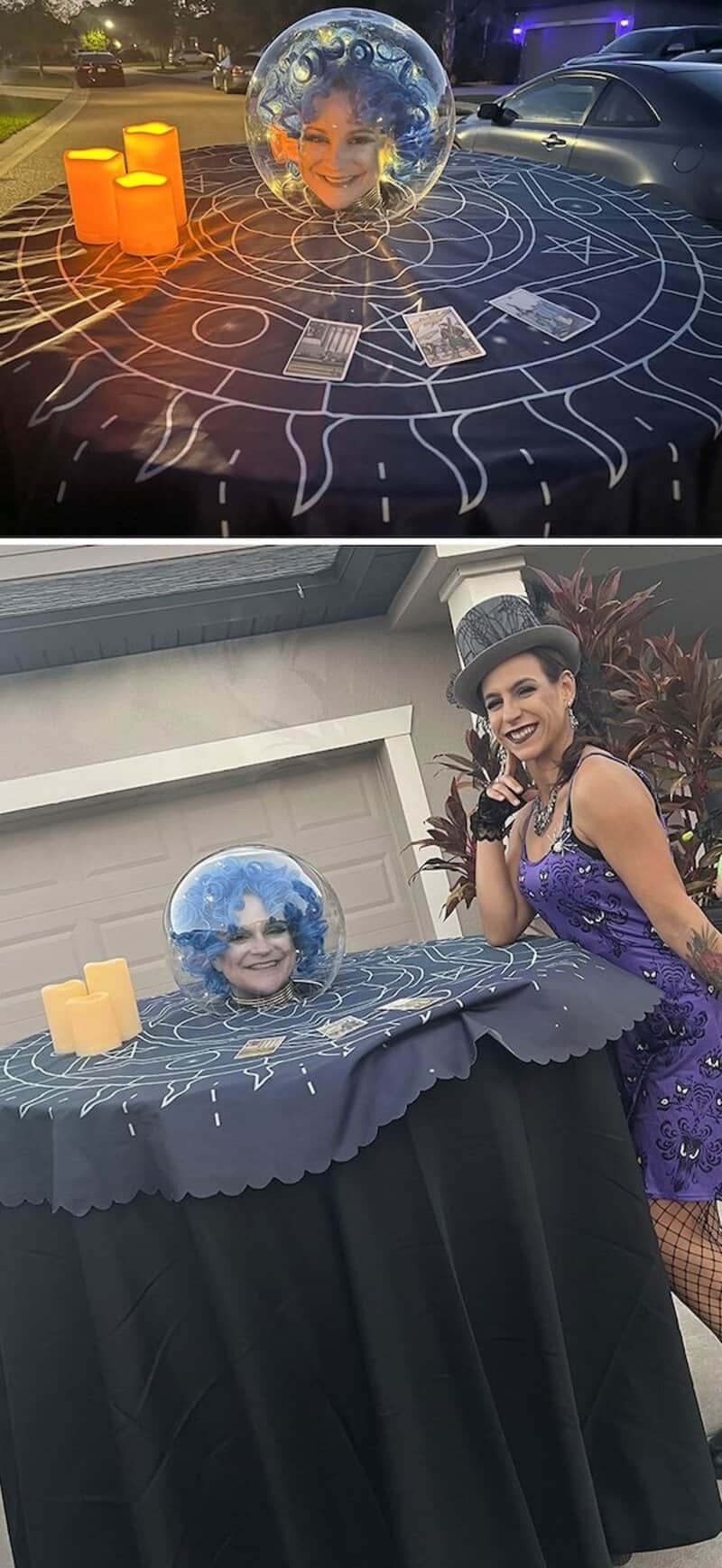 Person with blue orb head surrounded by candles and tarot cards on a mystic table, Halloween setup.