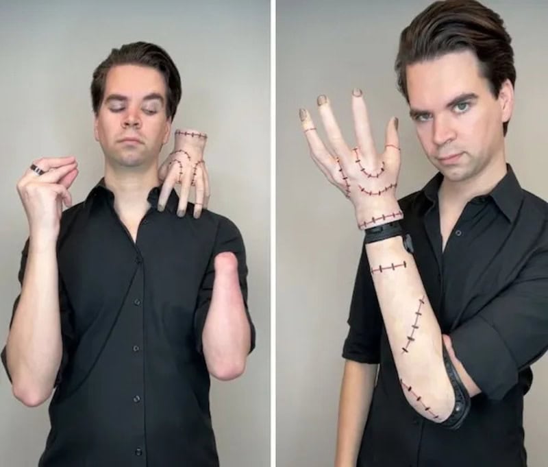 Man in black shirt showing stitched costume on arm and hand.