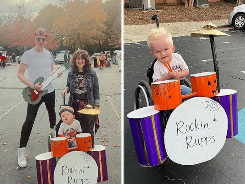 People costumed with a drum set; a child in a wheelchair plays the drums while others pose nearby.