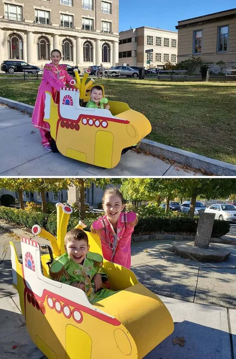 Two children in colorful outfits pose with yellow cardboard helicopter cutouts on a campus lawn.