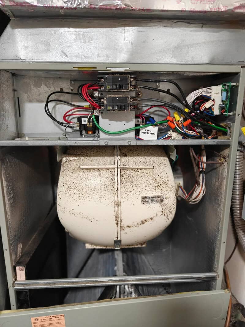 Electrical components inside a malfunctioning machine with a dirty, dusty interior.