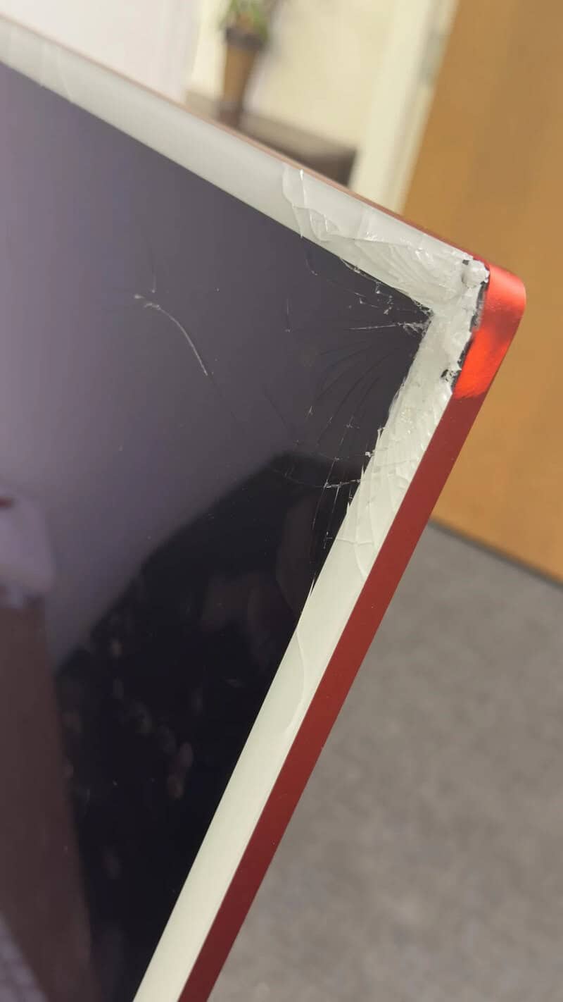 Broken computer monitor with cracked screen and damaged frame.