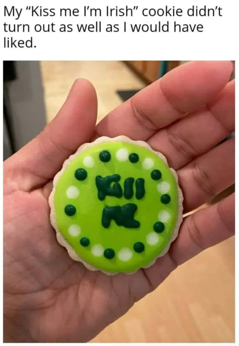 Funny green cookie with text I’LL KISS ME written in dark letters in the center.