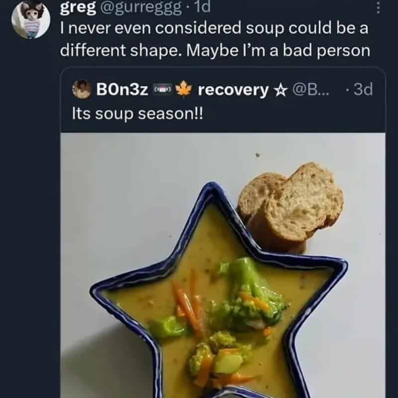 A bowl of soup in a star-shaped blue dish with vegetables; two slices of bread on the side.