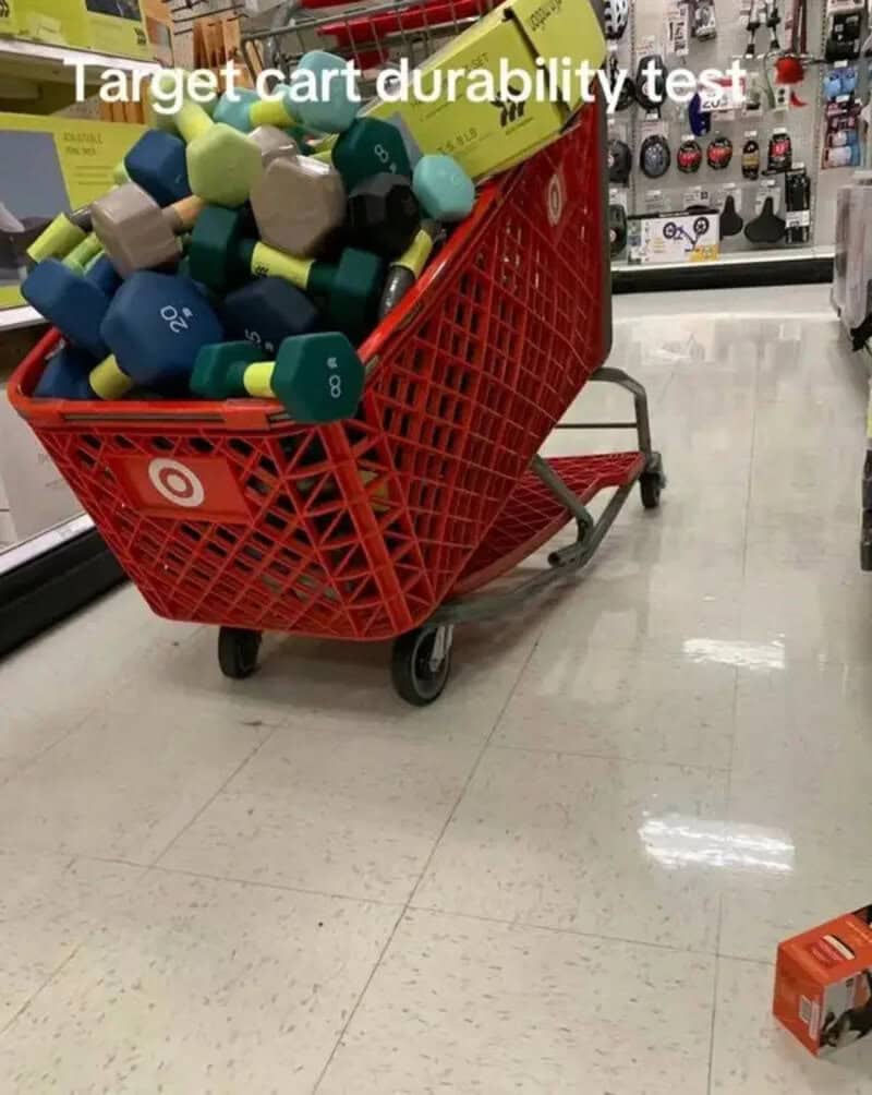 Red Target shopping cart filled with colorful dumbbells for durability test.