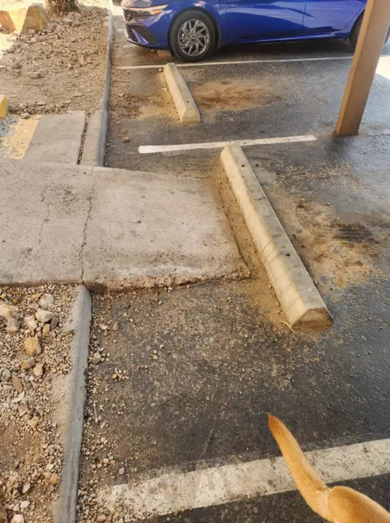 Poorly designed parking lot with uneven and confusing parking space lines.