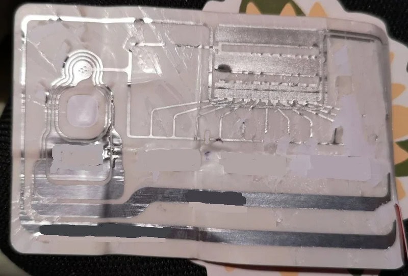 Close-up of a metallic electronic circuit with various components and connections.