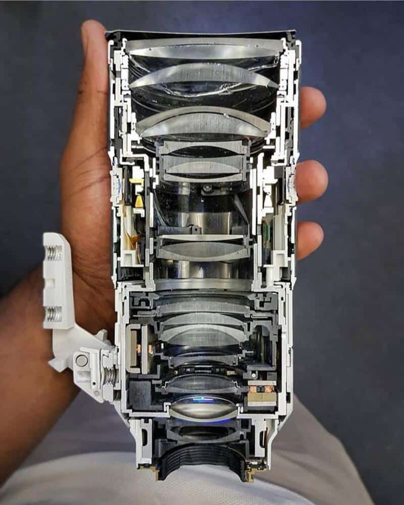 Cut in half: internal components of a complex electronic device with lenses and circuits.