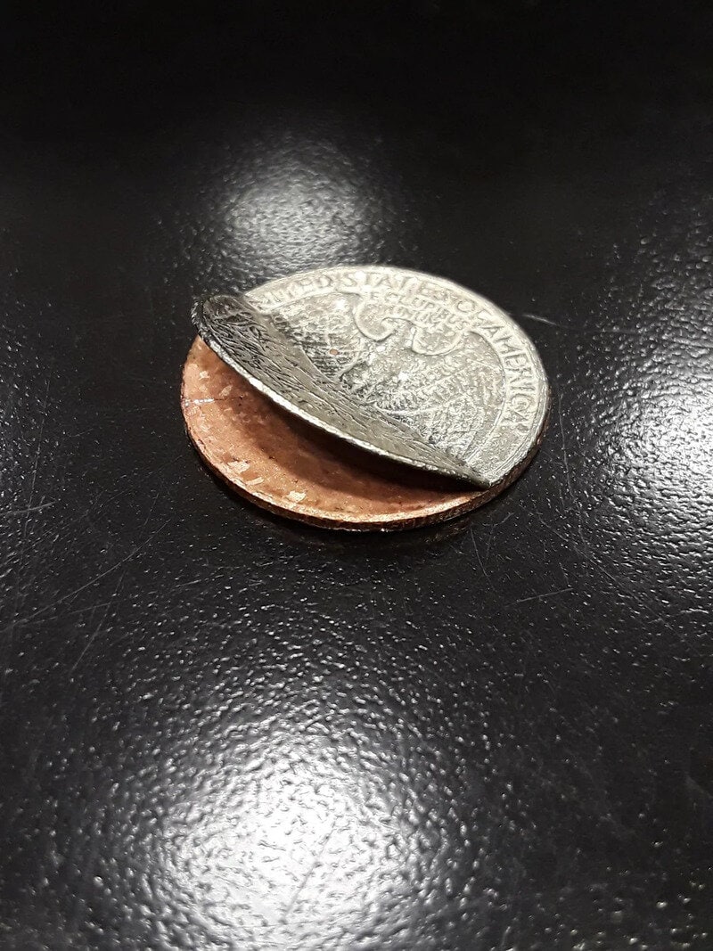 A coin that is cut in half, showing both the front and back sides.
