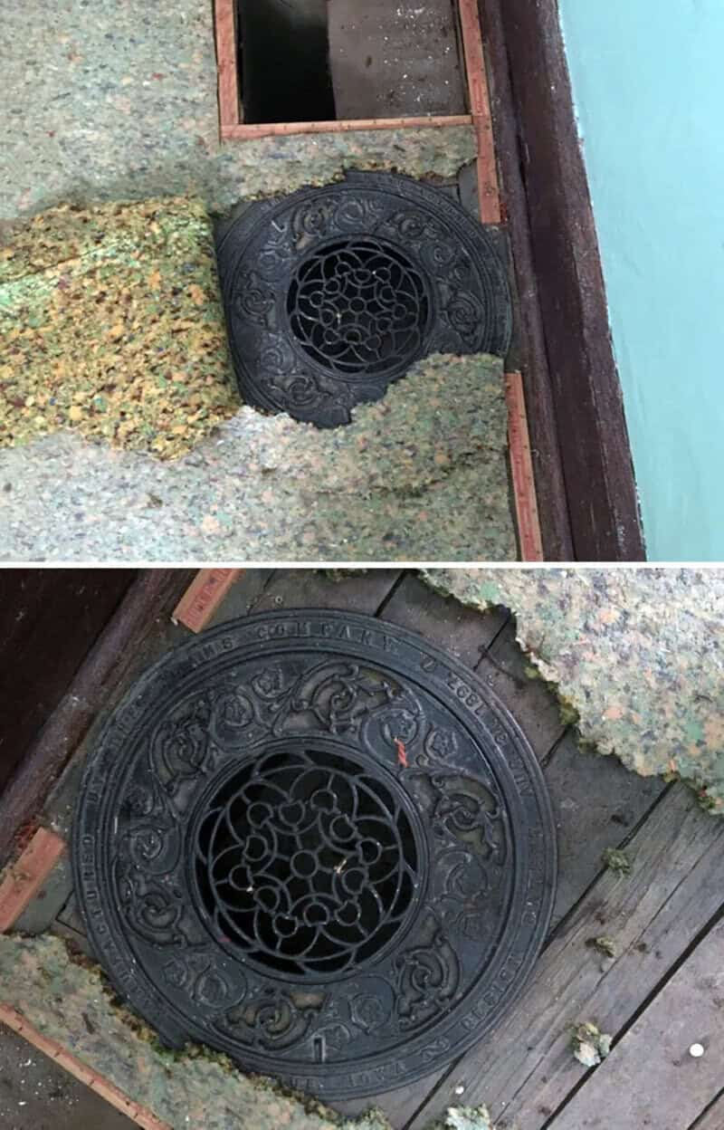 Old decorative manhole cover with intricate design, partially covered by gravel and wood.