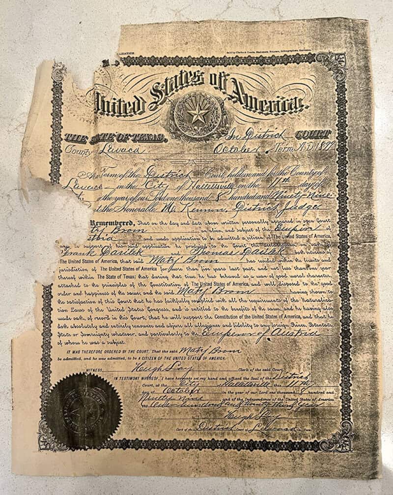 Old, torn, and faded US government document with a seal and signature.