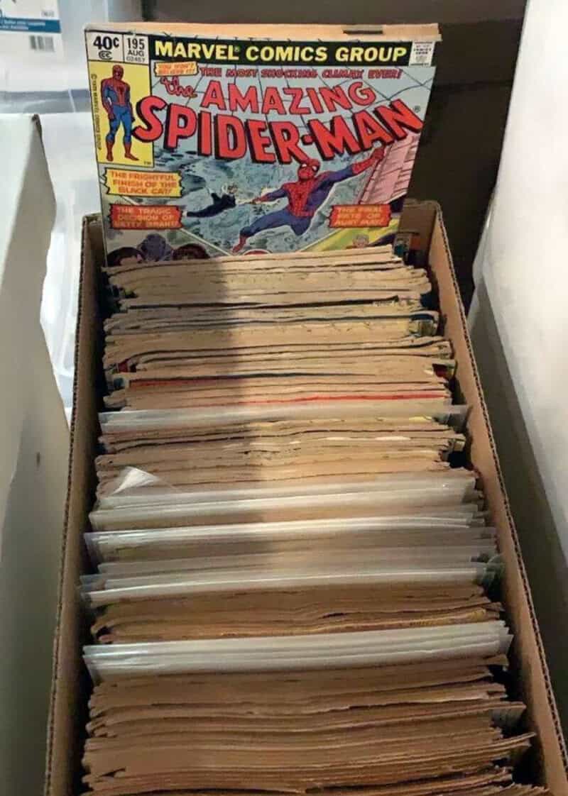 Box of vintage comic books, including Amazing Spider-Man issue on top.