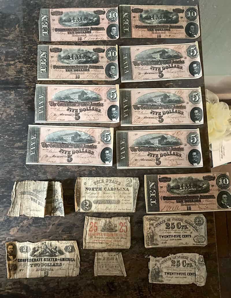 Old, worn paper currency bills from various states and denominations.