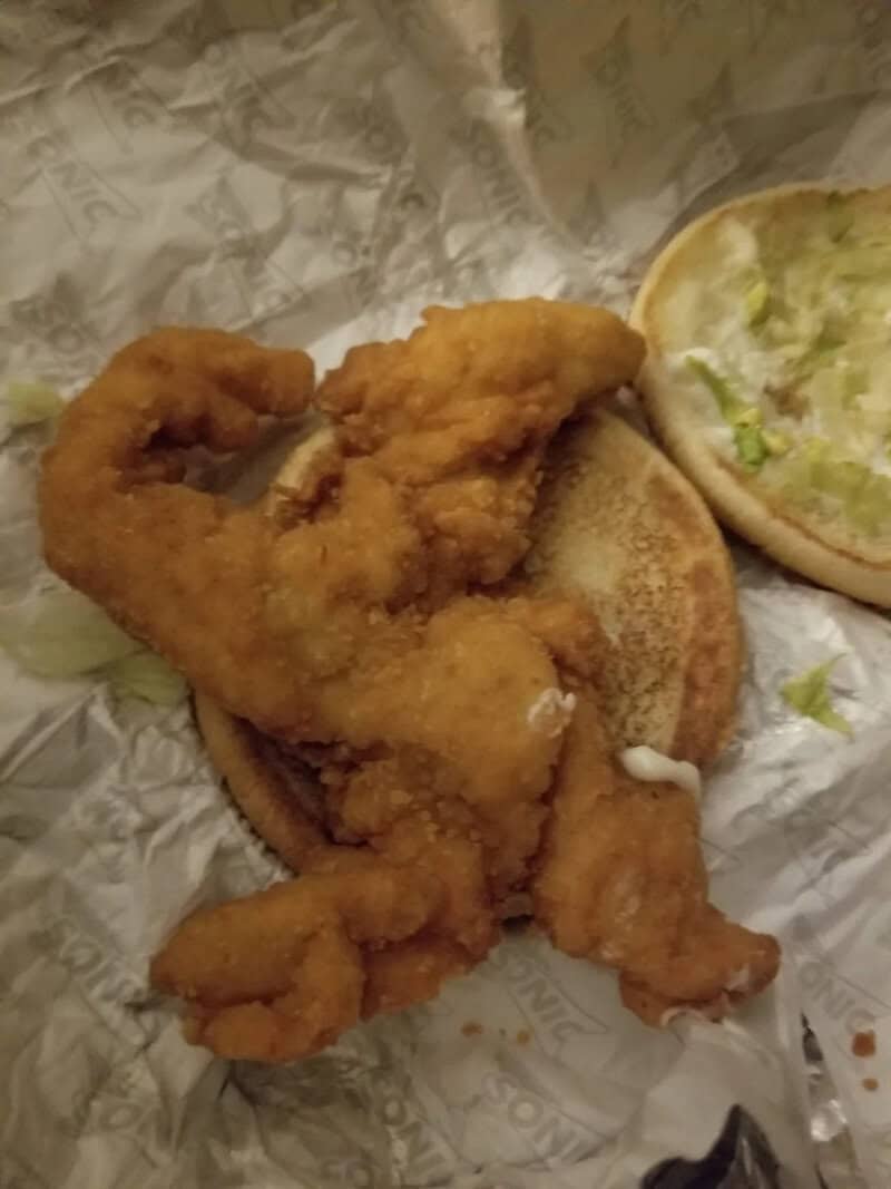 Fried chicken tender on a sandwich bun with lettuce and mayonnaise.