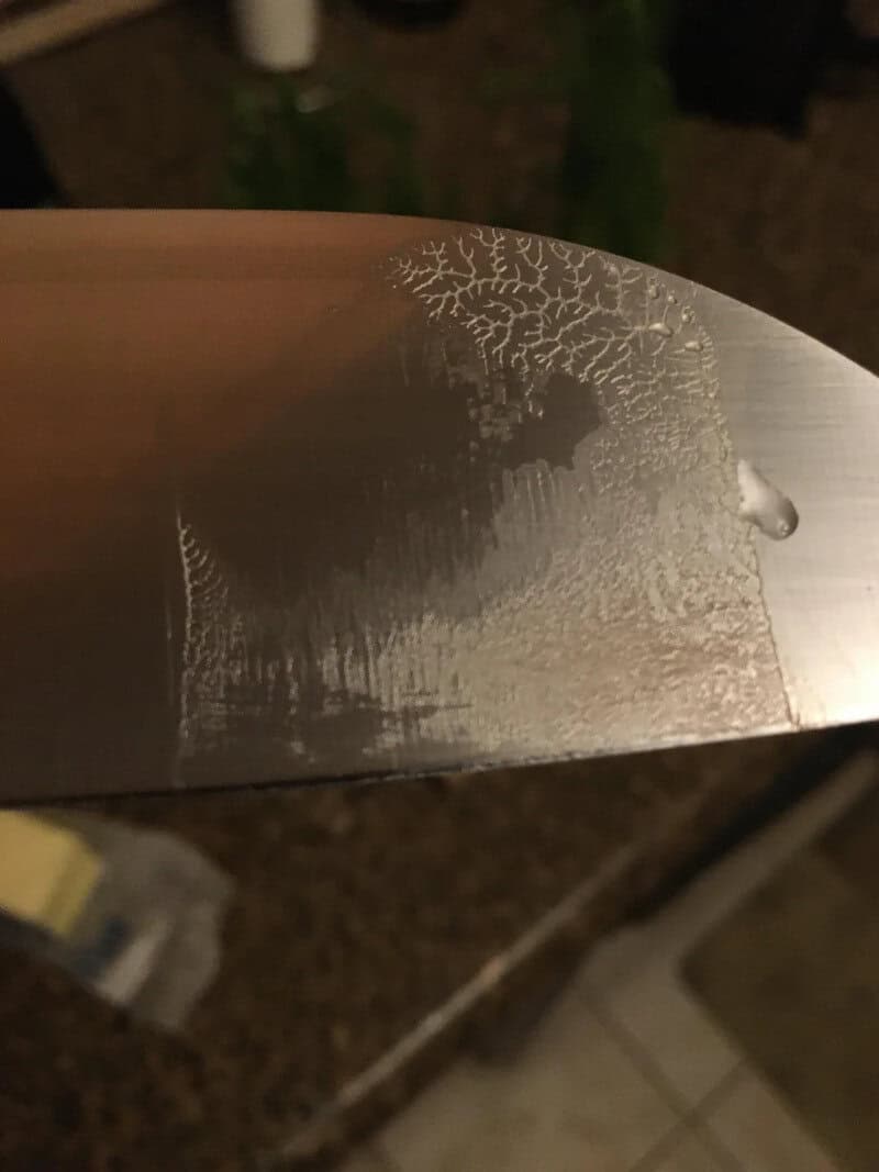Close-up of a knife blade with frost patterns resembling a tree.