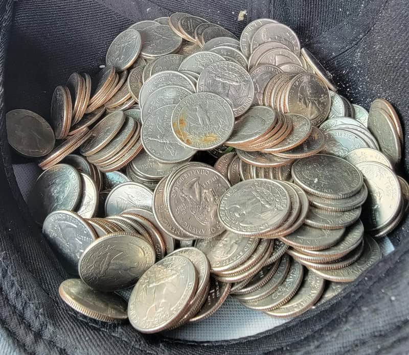 A large collection of U.S. quarters in a black bag.