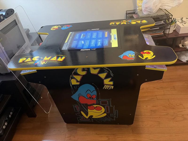 Pac-Man arcade game machine with colorful graphics and touchscreen interface.