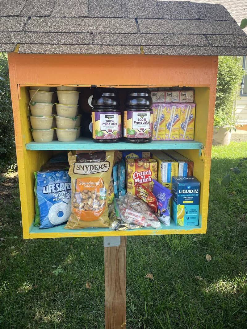 Community food pantry with various food items and containers inside.