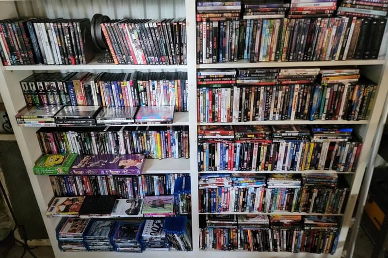 Bookshelves filled with DVDs and Blu-rays in a room.