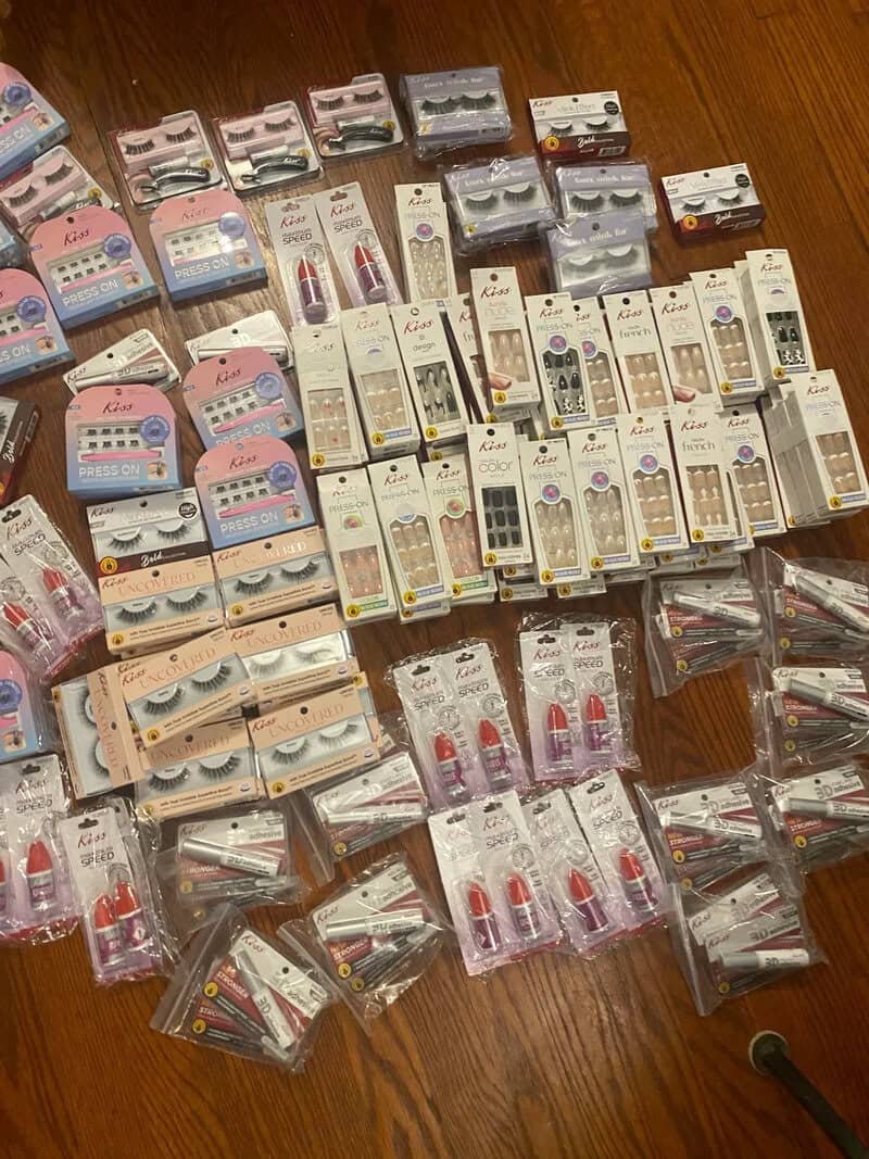 Various makeup and beauty products laid out on a wooden floor.