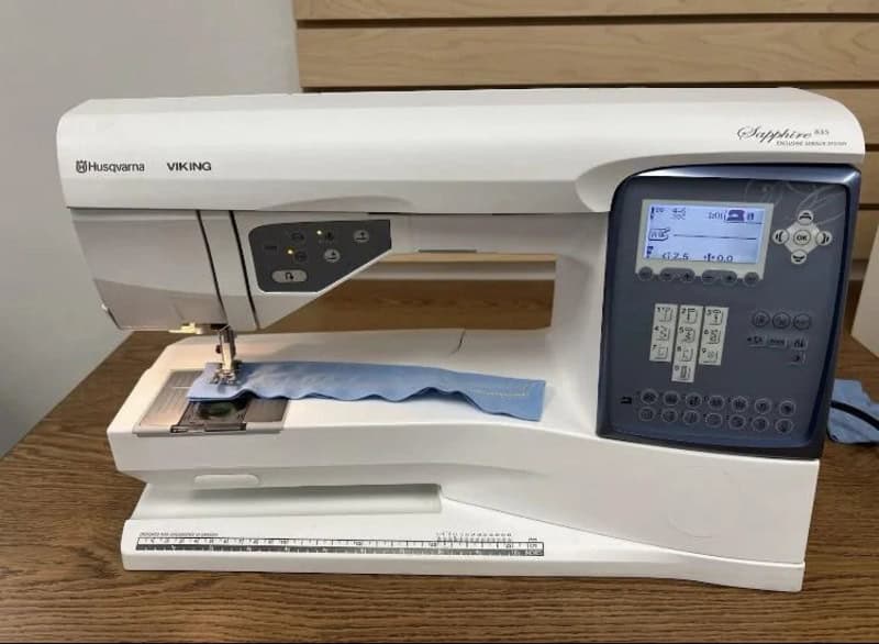 Husqvarna Viking Sapphire 930 sewing and embroidery machine on a wooden table.
