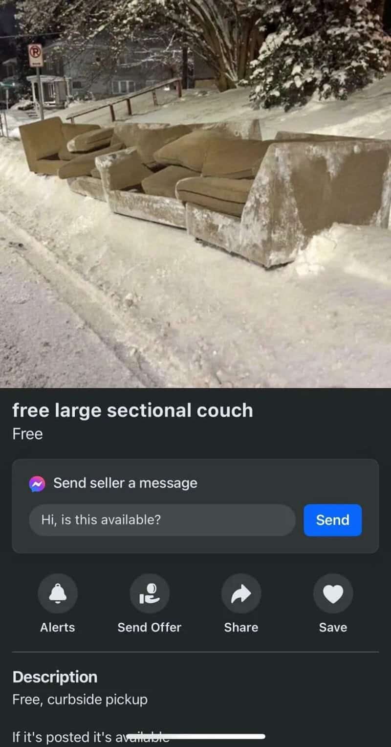 Large sectional couch covered in snow on a sidewalk, with trees and a street in the background.