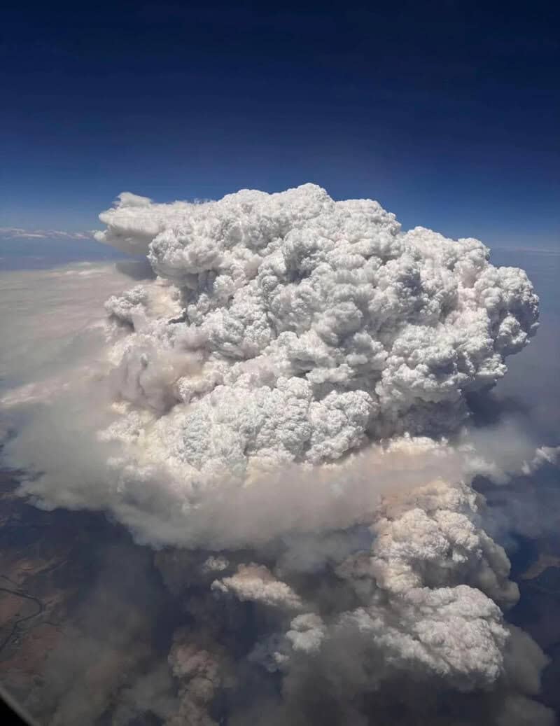 Large, dense cloud formation with a clear blue sky background.