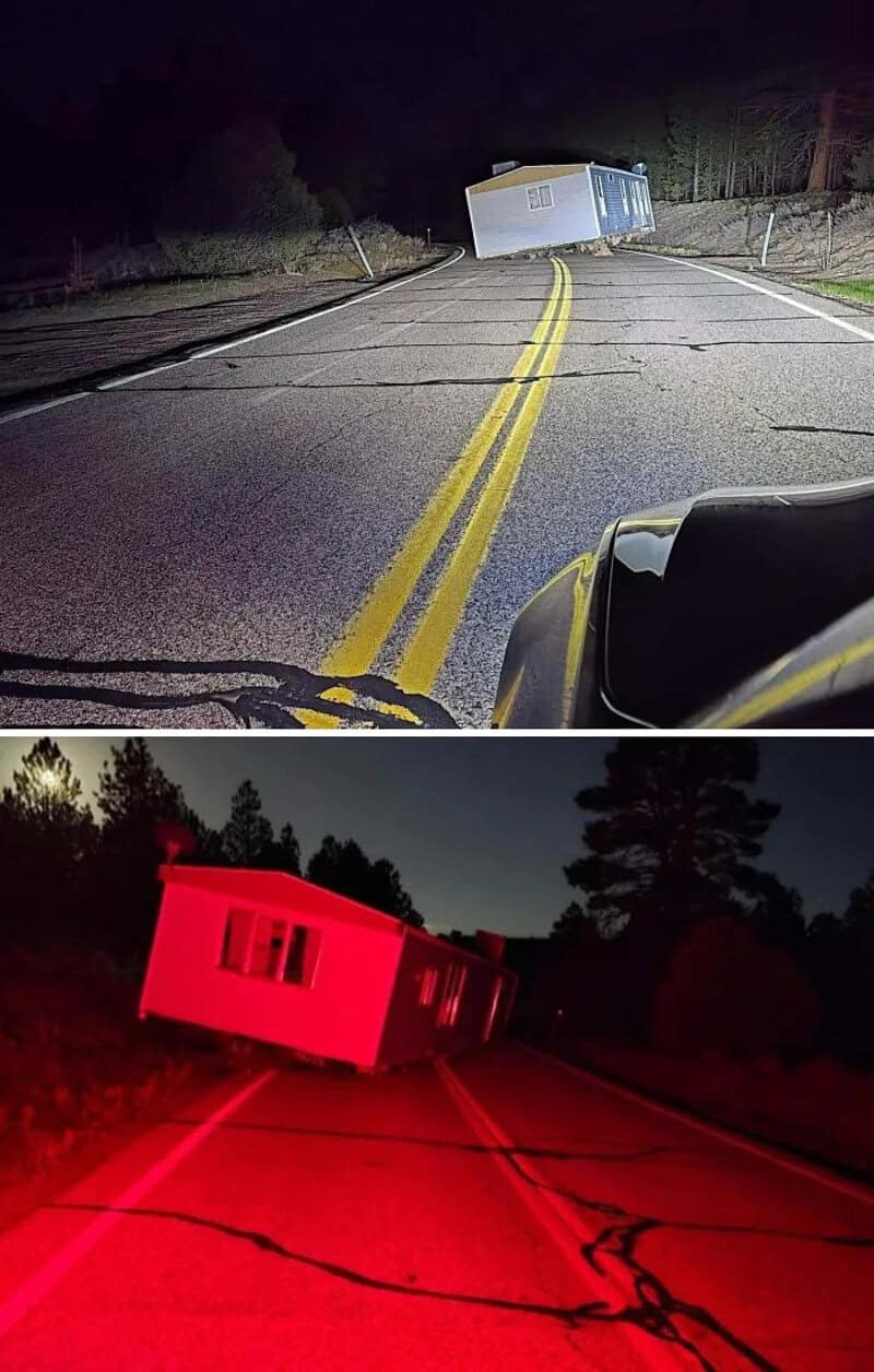 Truck tipped over on a dark road, seen from inside a vehicle at night.