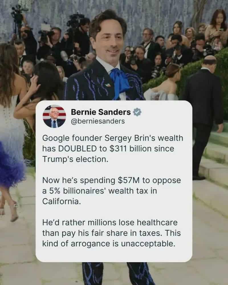 Man in suit with blue tie at a gala with photographers in background; overlaid tweet about wealth of.