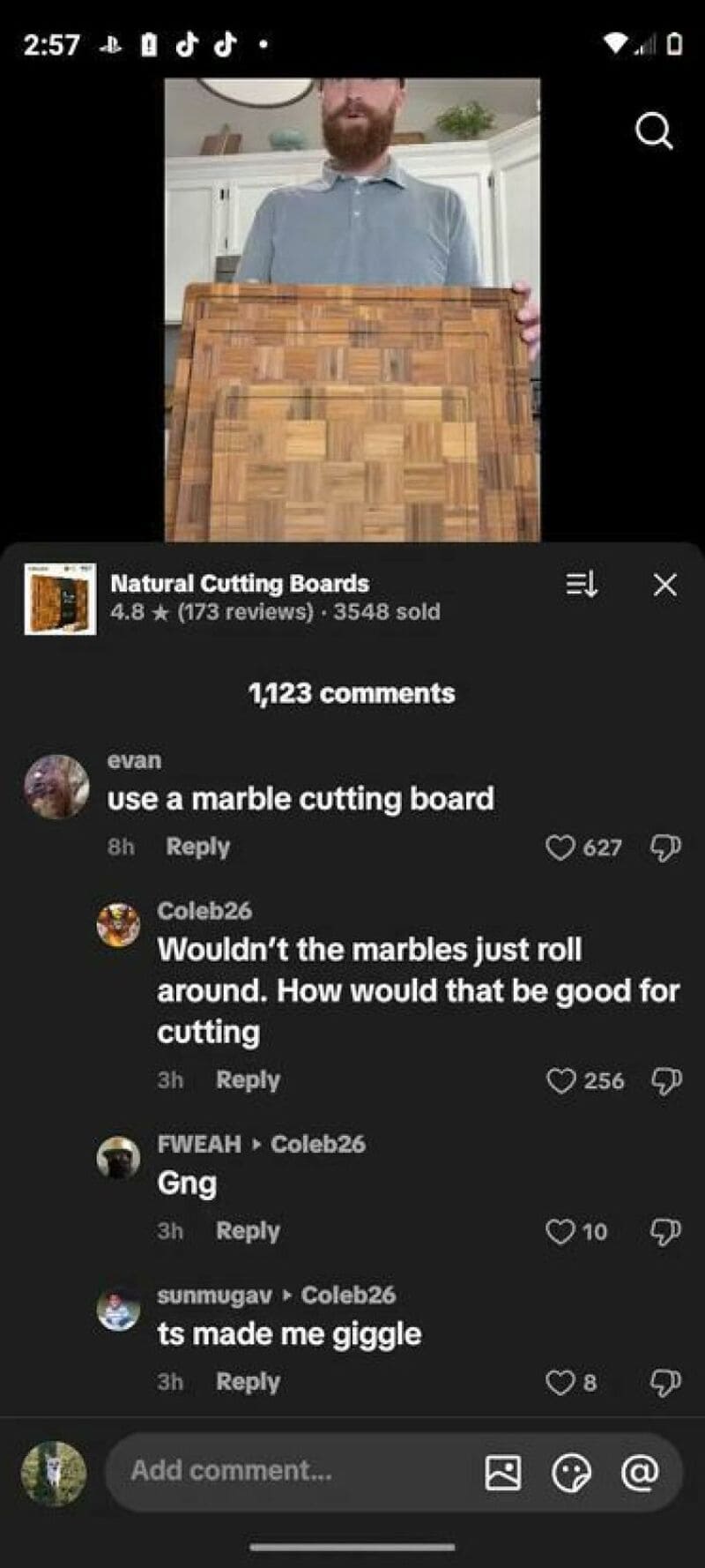 Man holding a large wooden cutting board in a kitchen.