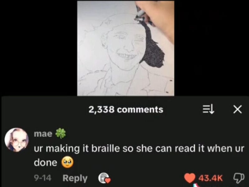 Drawing of a smiling person's face being created with a black pen.