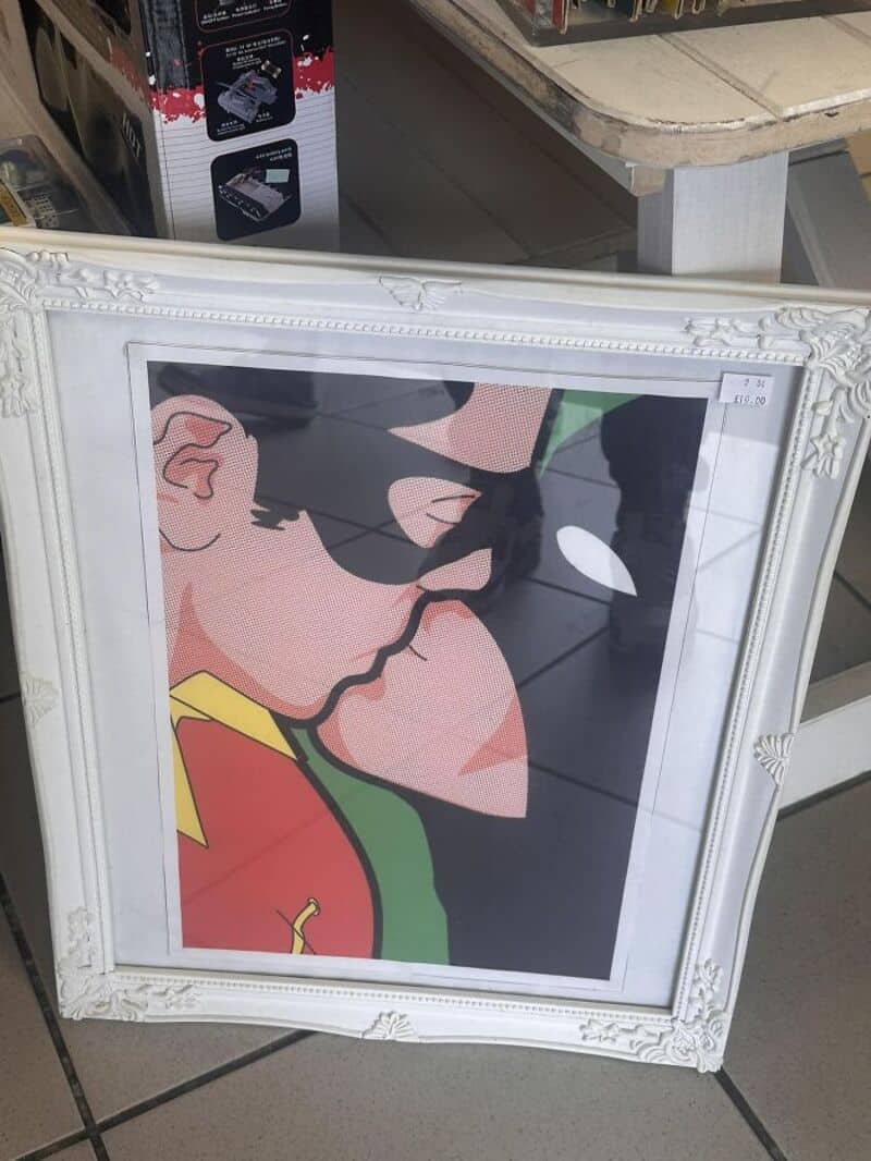 Framed pop-art style image of a person with black sunglasses and a red-yellow-green outfit, side-on.
