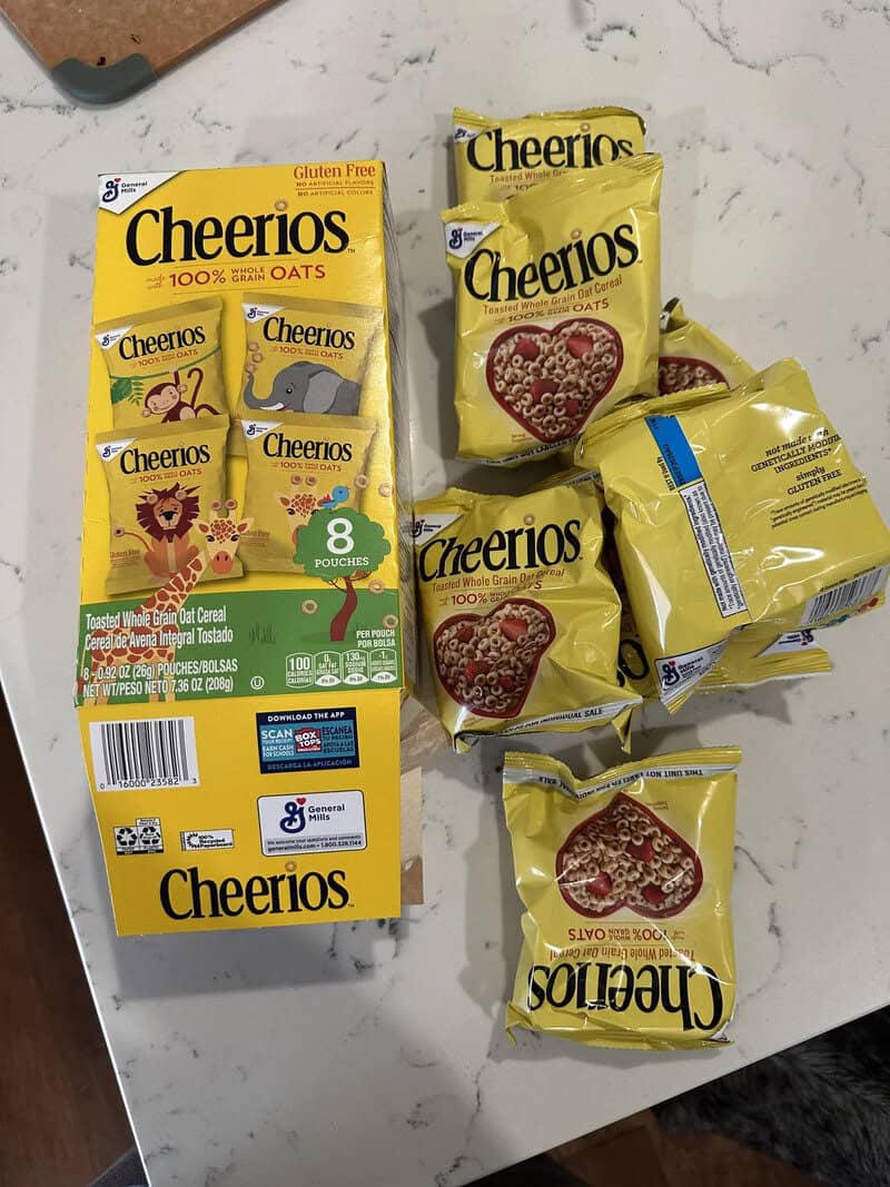 Cheerios cereal boxes and pouches on a white surface.