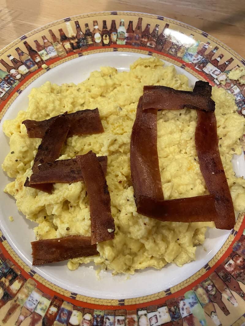 Scrambled eggs with bacon forming the number 40 on a decorative plate.